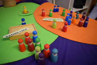 Ökumene mit Spielfiguren dargestellt